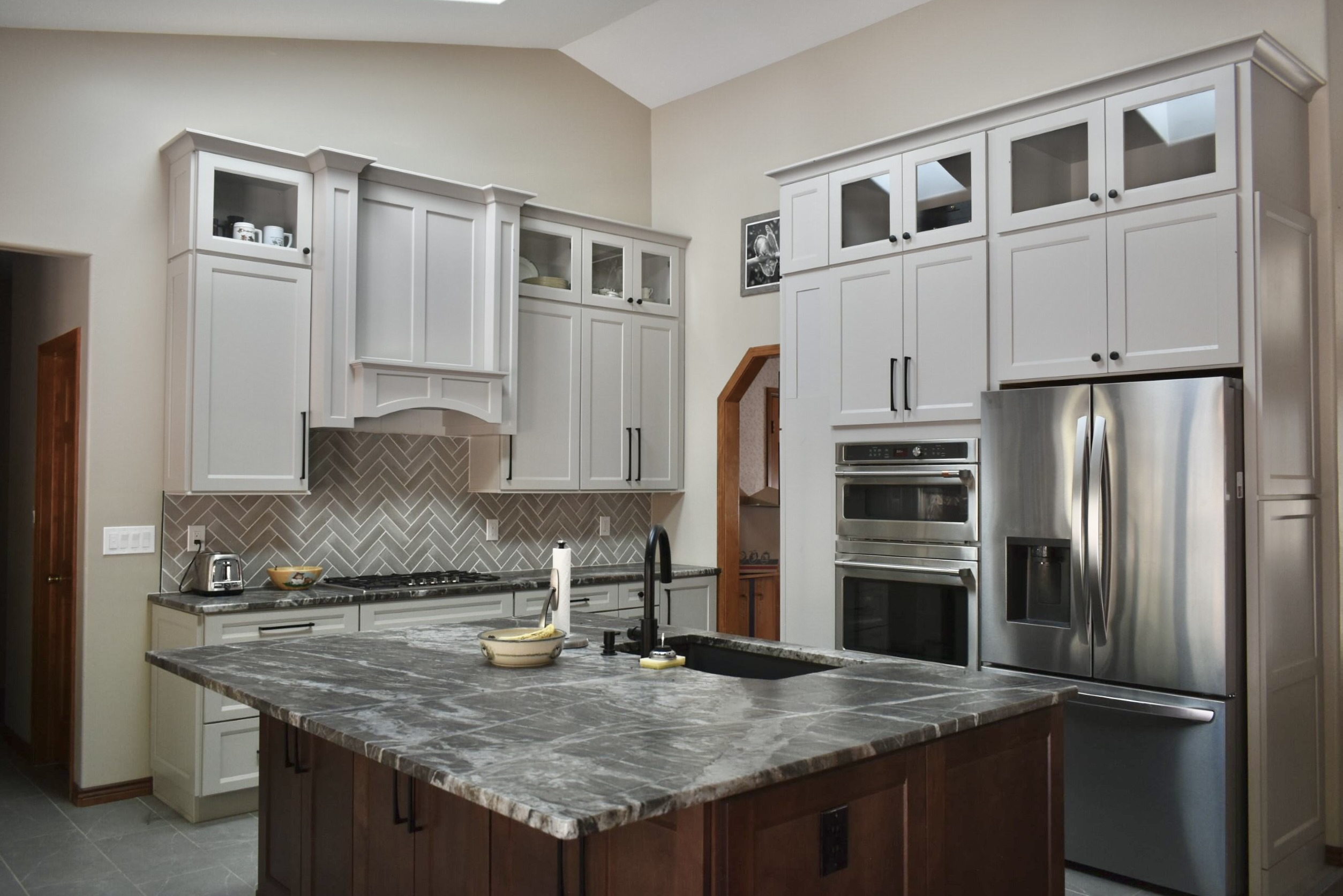 Custom kitchen with wrought iron chandelier and dark island
