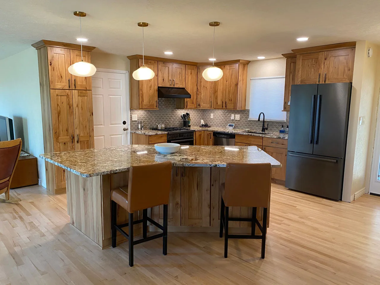 L-shaped kitchen island remodel with light wood cabinetry