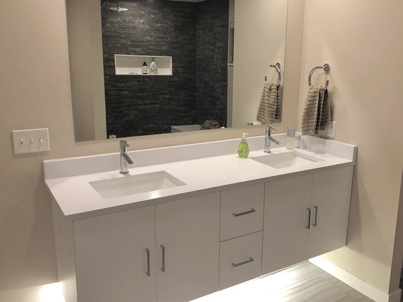 Modern double vanity bathroom with under-vanity lighting by MTD Construction