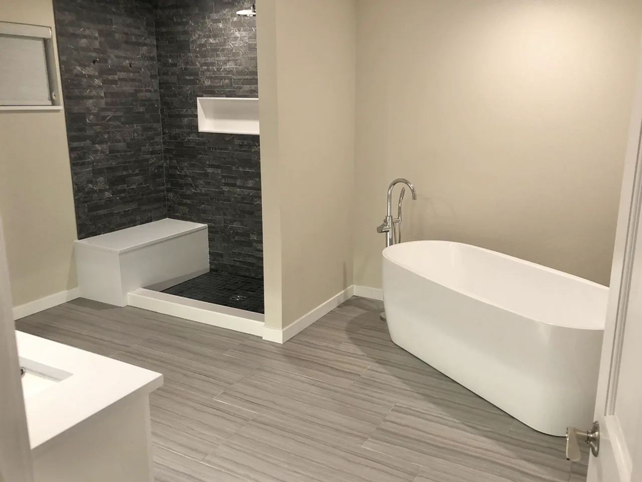 Spa bathroom with freestanding soaking tub and stone shower by MTD Construction