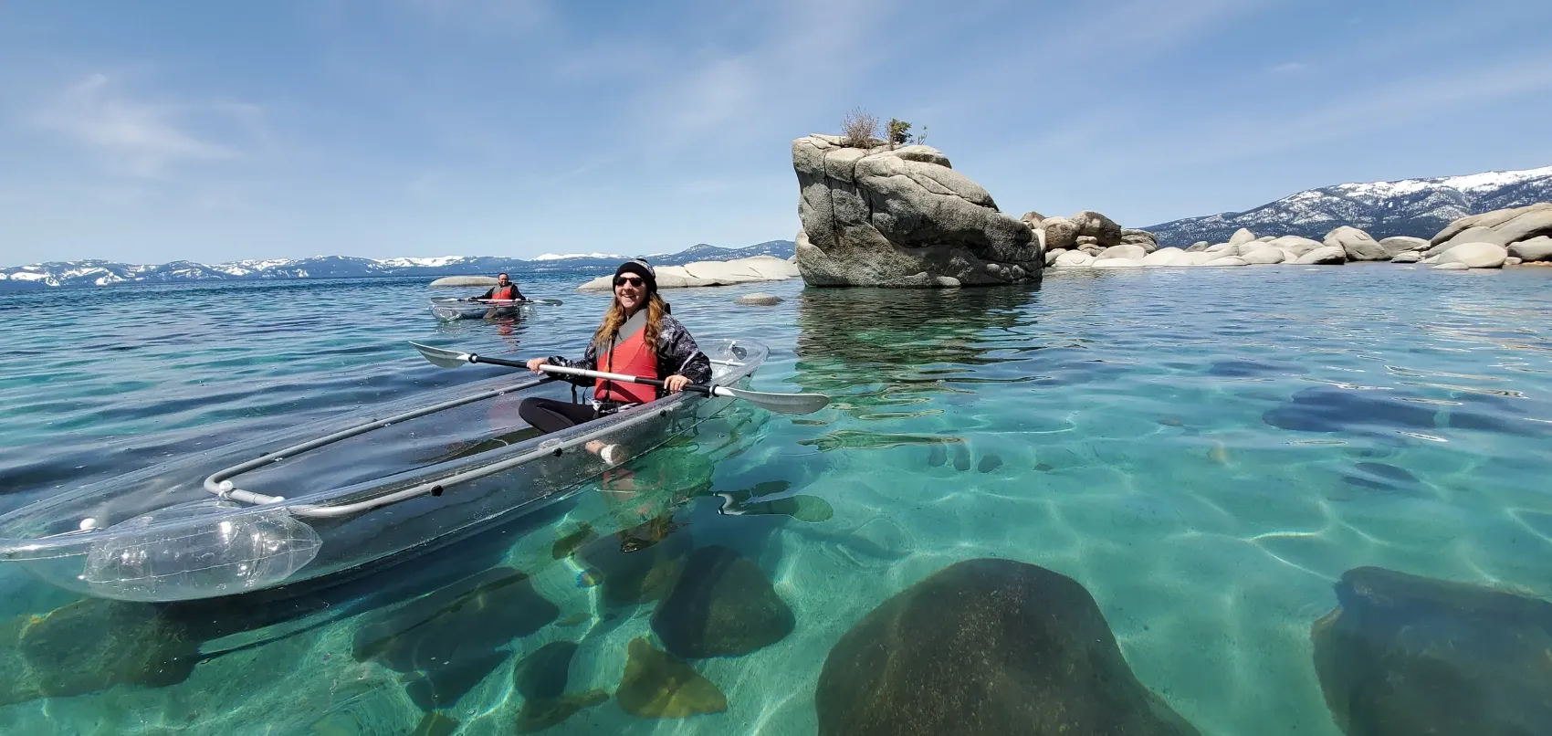 Guides leading clear kayaks across Lake Tahoe's turquoise water near Bonsai Rock