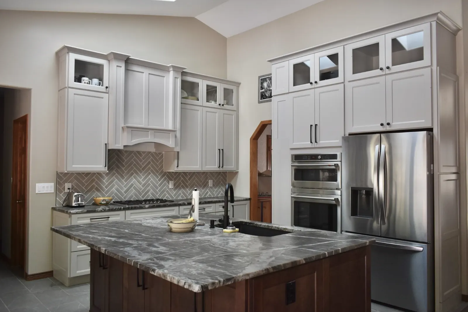 Custom kitchen with wrought iron chandelier and dark island