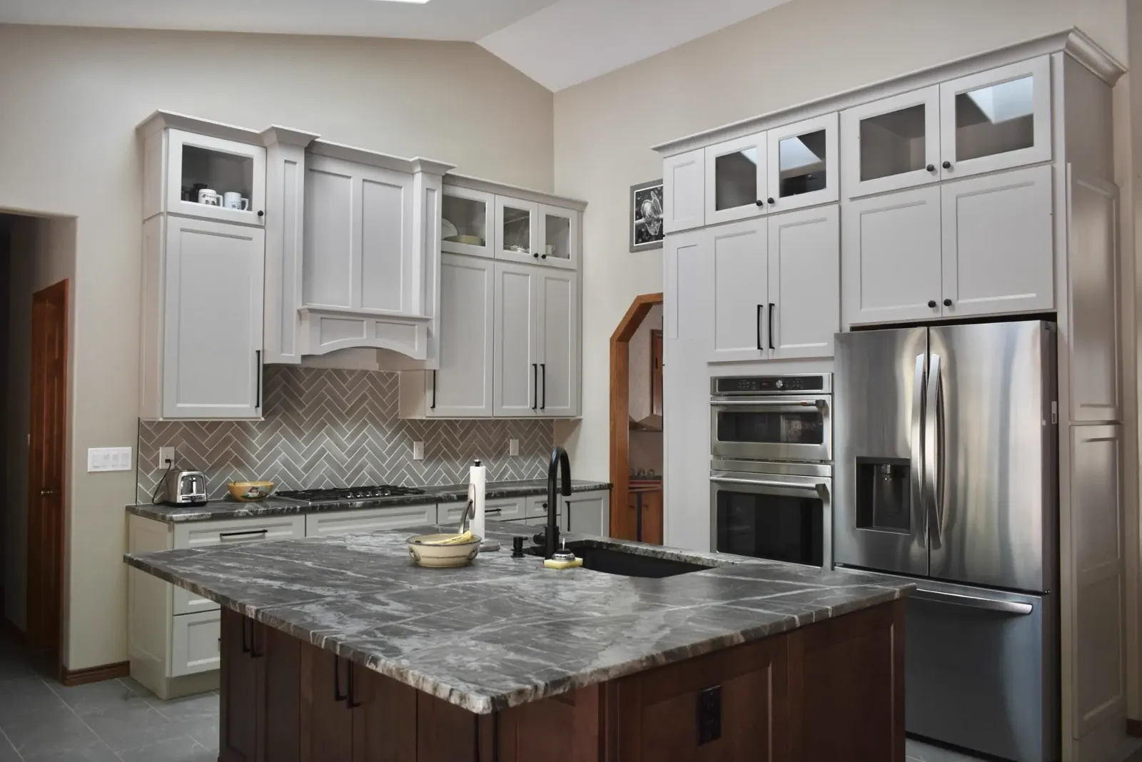 Custom kitchen with wrought iron chandelier and dark island