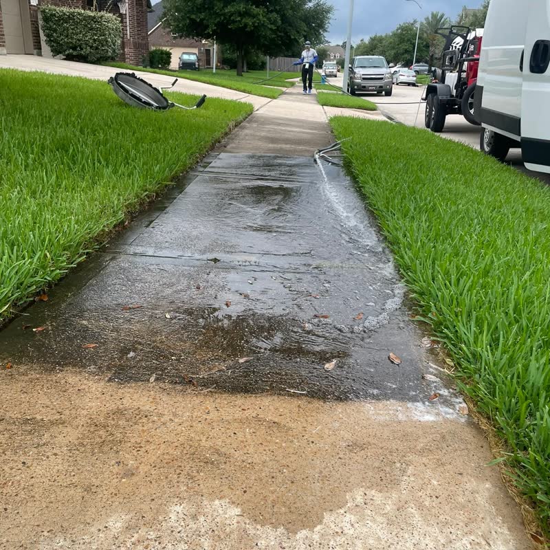 Freshly washed wet sidewalk with H2O Prime service truck in the background