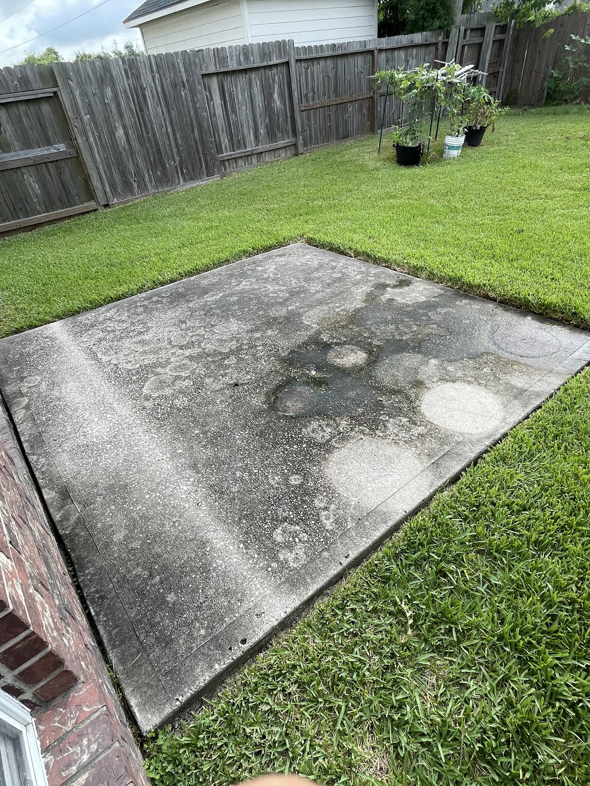 Dirty, stained concrete patio before pressure washing in Houston
