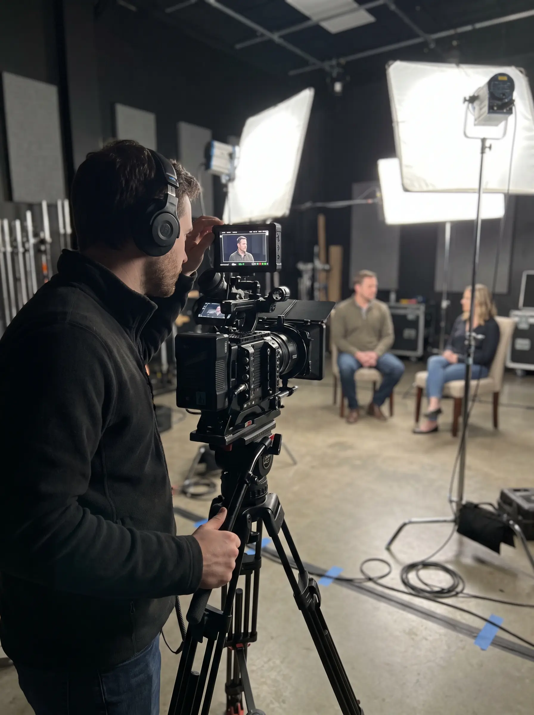Videographer filming an interview with studio lighting