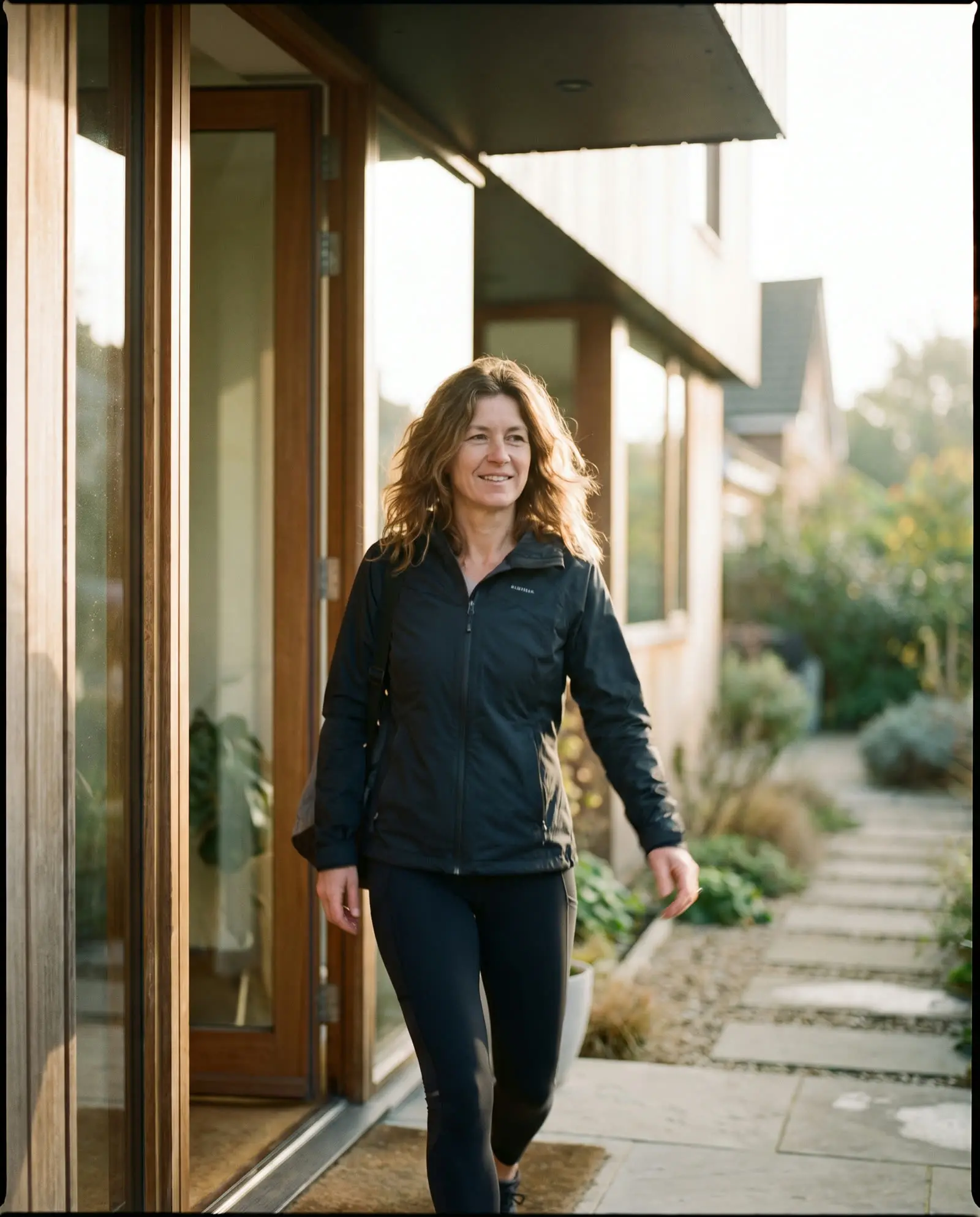 A woman walking out of her home into the morning light