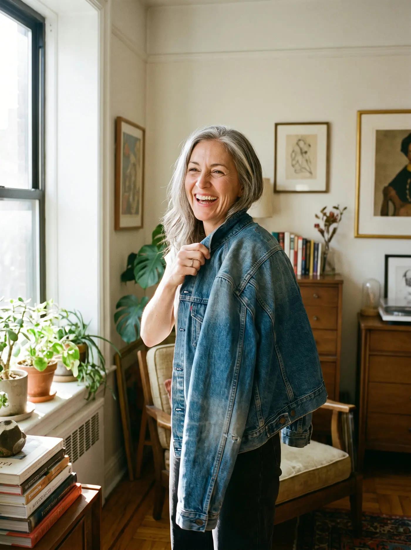A woman smiling as she tries on a favorite outfit