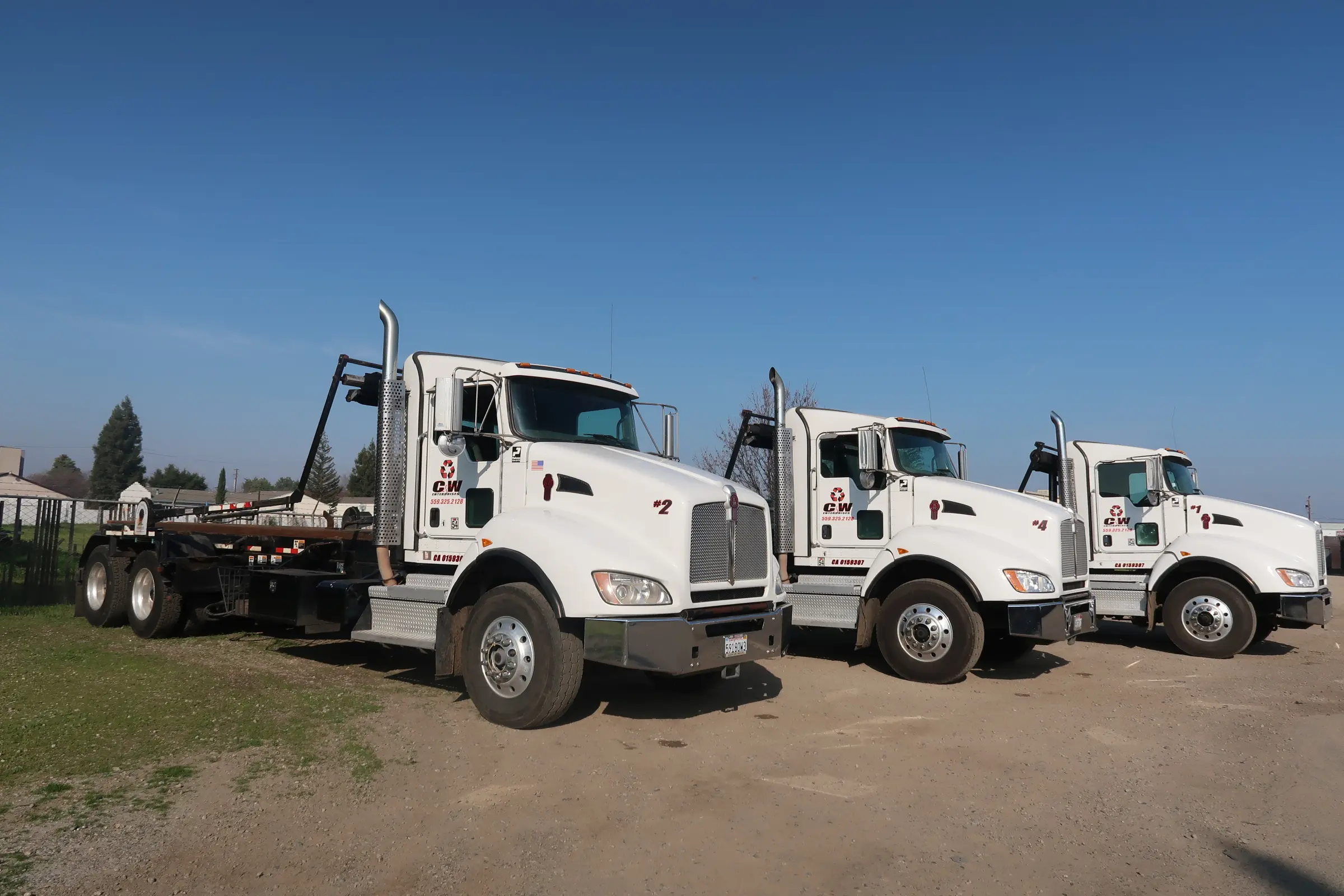 Three C&W roll-off trucks lined up