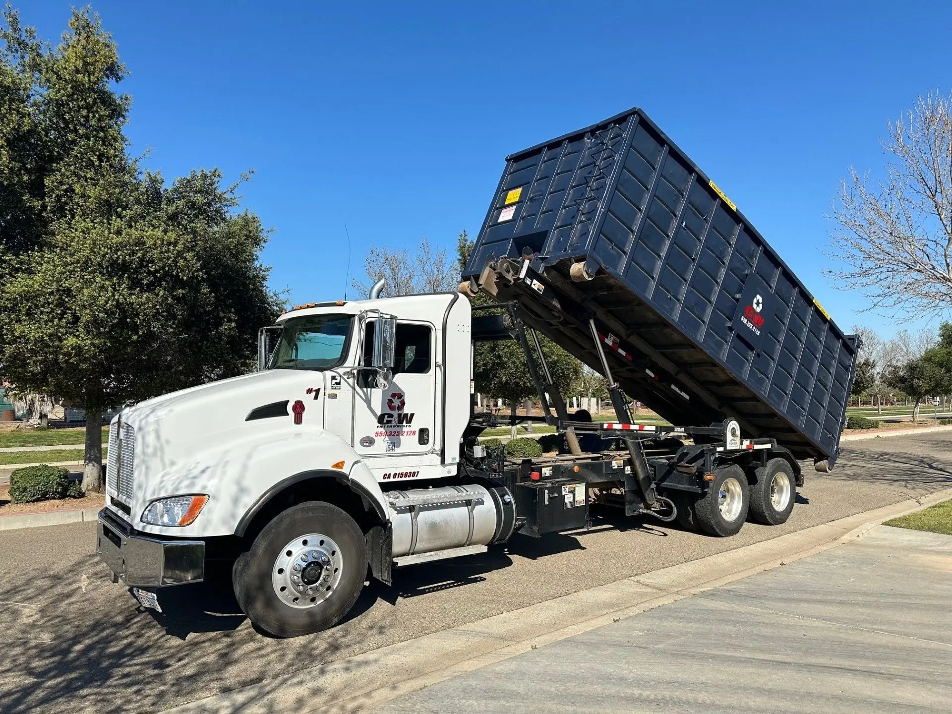 C&W roll-off truck dumping a container