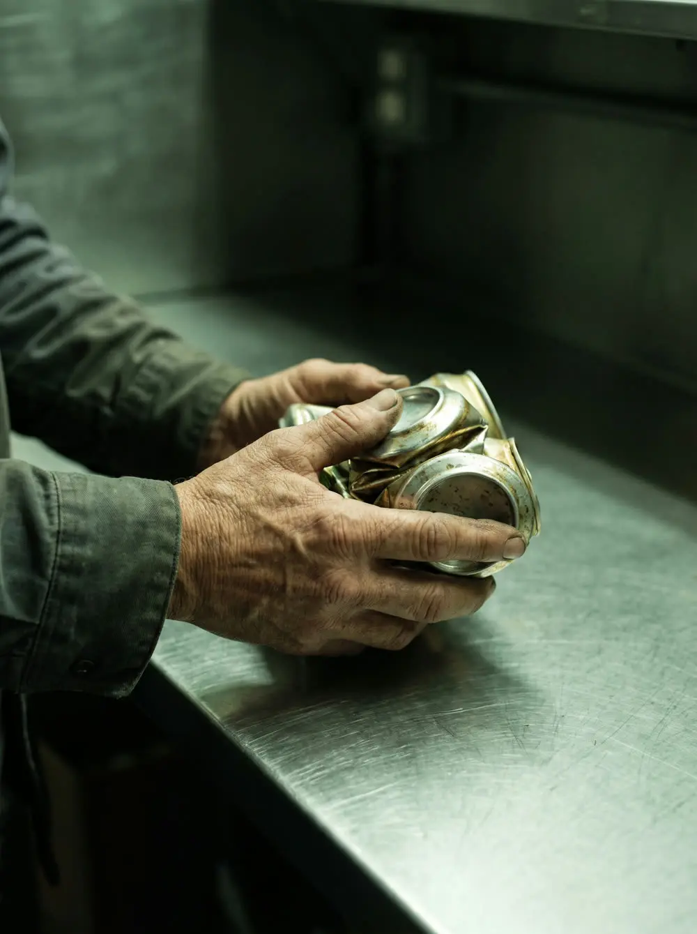 Hands holding crushed aluminum cans