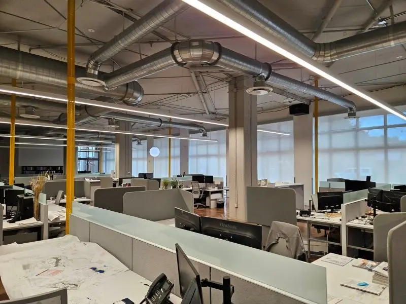 Open-plan commercial office interior with exposed ductwork